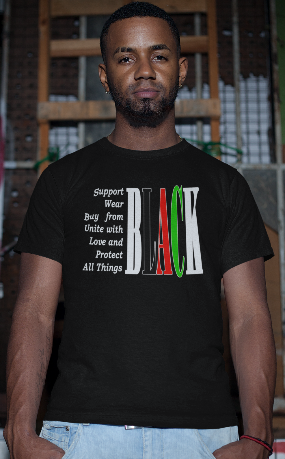 Man wearing a black t-shirt with colorful text in an urban setting
