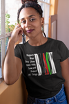 Woman wearing a black t-shirt with a message and rainbow design, standing indoors.