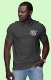 Man wearing a dark gray polo shirt with a logo on a light green background