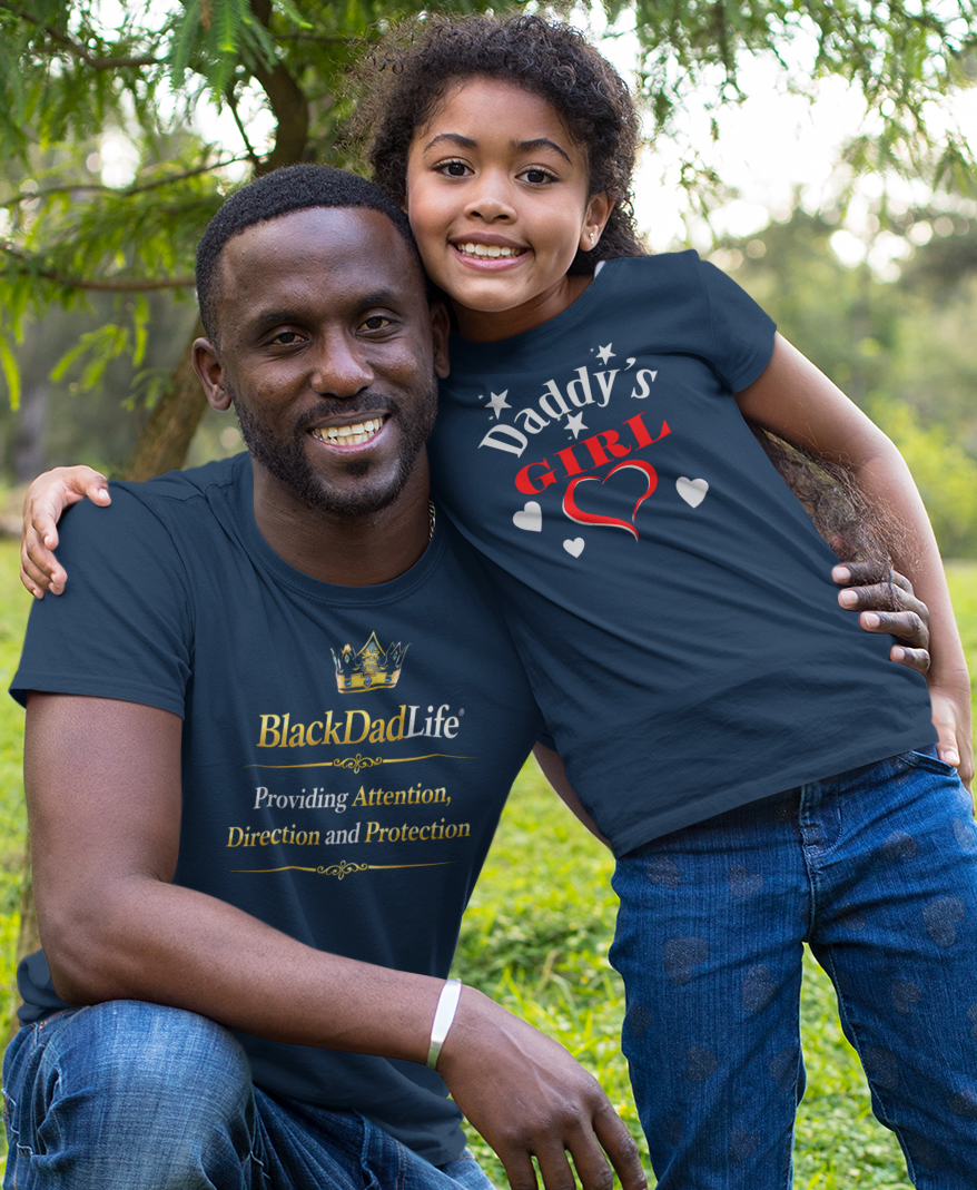 Man and child in matching outfits outdoors on a grassy area