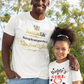 Man and young girl standing outdoors wearing matching white t-shirts with text.