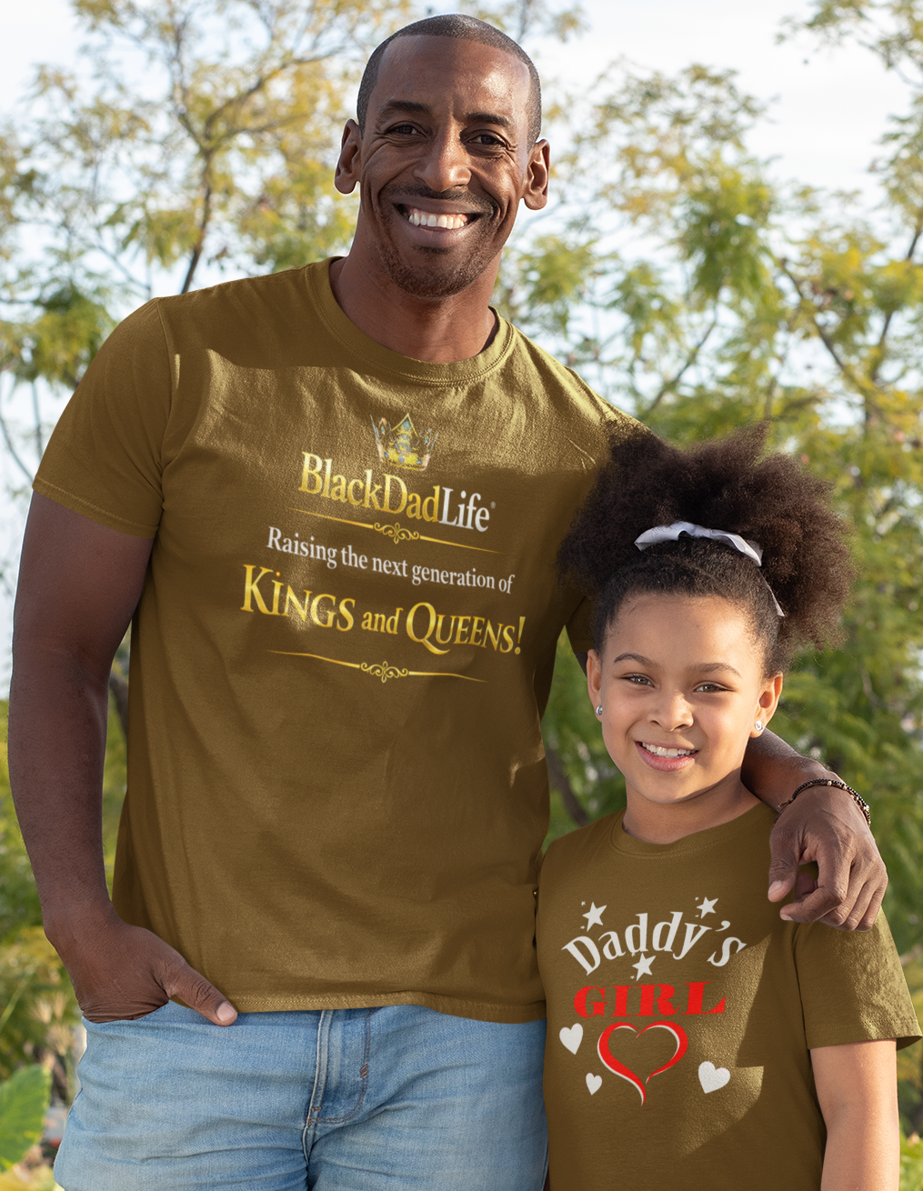 Man and young girl wearing matching brown t-shirts in a park