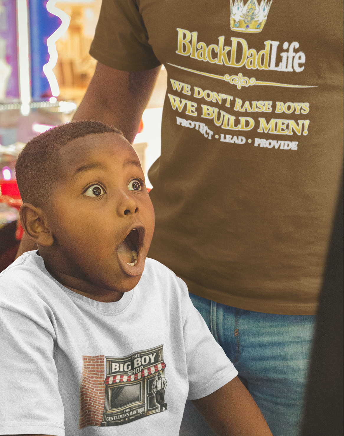 Child in a toy store with a surprised expression, wearing a 'Big Boy' t-shirt.