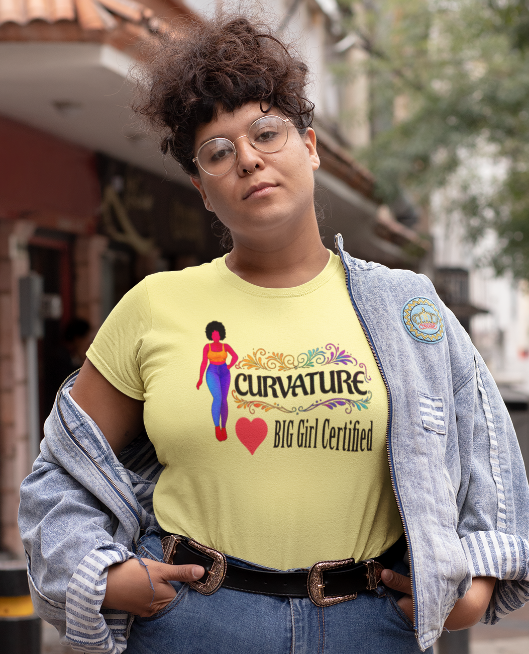 Person wearing a yellow t-shirt with text and graphics, standing on a street.