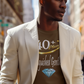 Man wearing a beige blazer over a graphic t-shirt on a city street