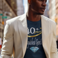 Man wearing a beige blazer over a graphic t-shirt on a city street