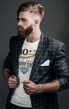 Man wearing a plaid blazer over a graphic t-shirt on a dark background
