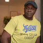 Man wearing a yellow t-shirt with text, standing indoors.