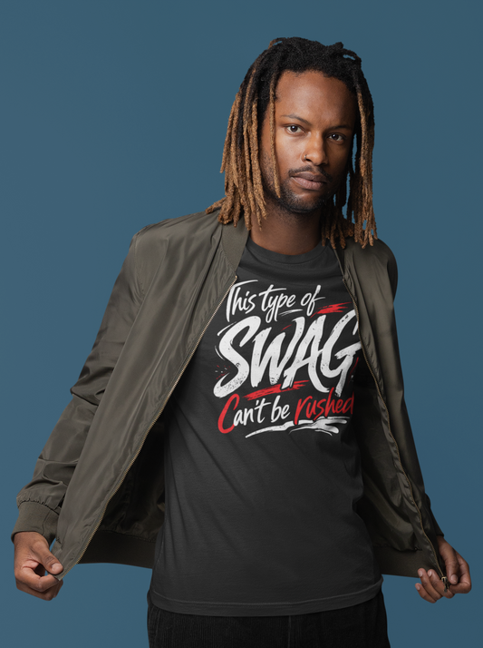 Man wearing a black t-shirt with text, dark pants, and a gray jacket on a blue background