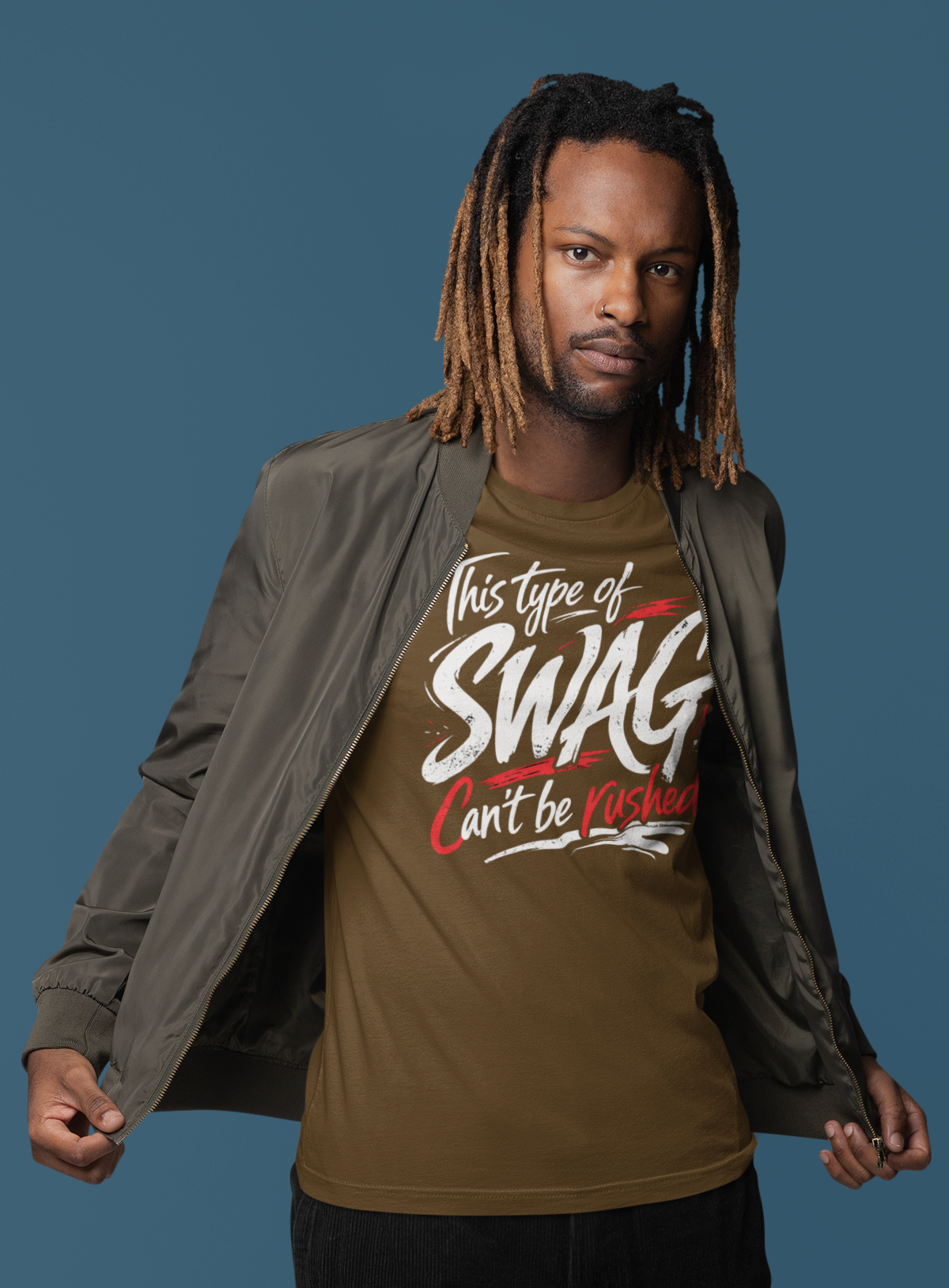 Man wearing a brown t-shirt with text, black pants, and white shoes against a blue background