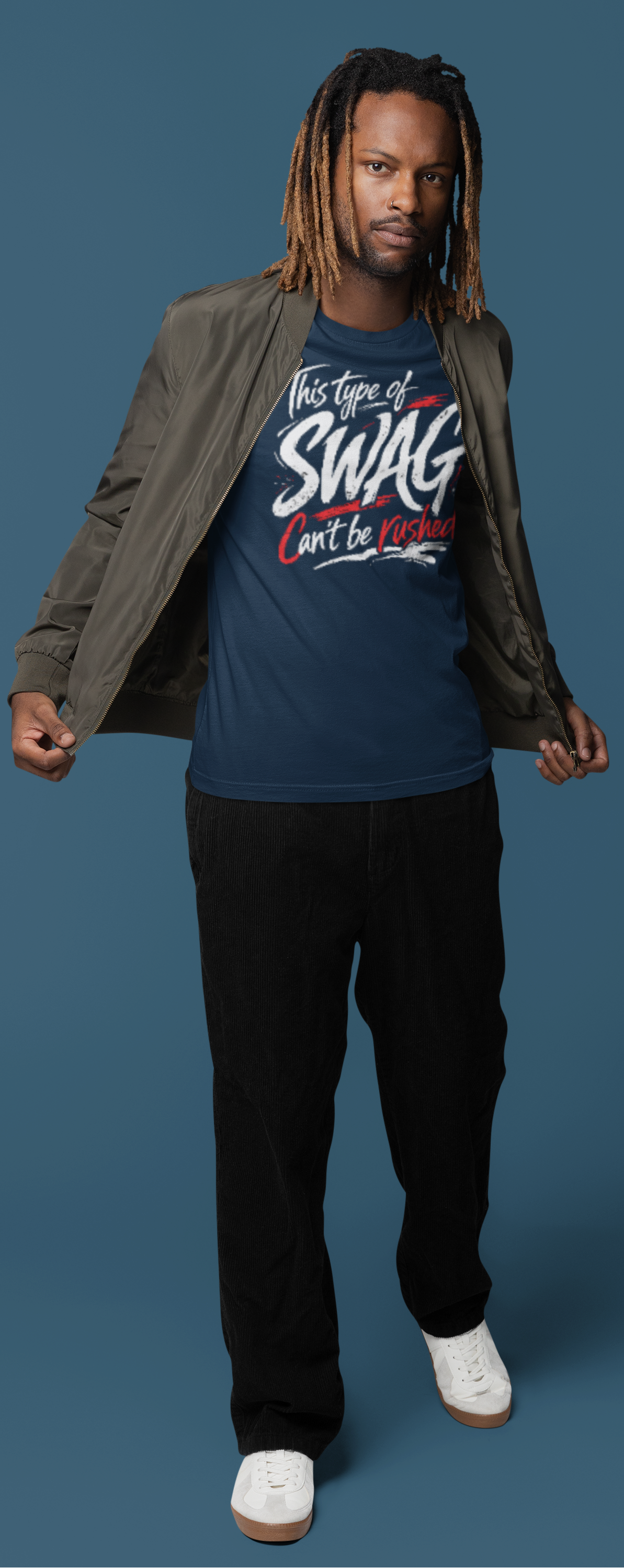 Man wearing a blue t-shirt with text, black pants, and white shoes on a blue background