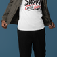Man wearing a white t-shirt with text and a jacket on a blue background