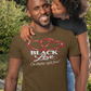 Man wearing a 'Black Love' t-shirt with a woman embracing him outdoors.