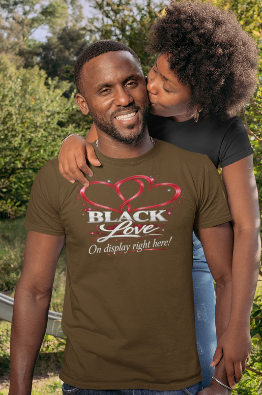 Man wearing a 'Black Love' t-shirt with a woman embracing him outdoors.