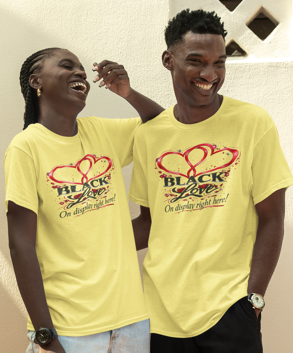 Two people wearing yellow t-shirts with a heart design, standing outdoors.