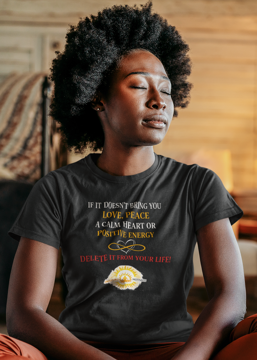 Person sitting in a meditative pose wearing a t-shirt with text and graphics.