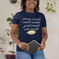 Woman wearing a navy blue t-shirt with text, holding a tablet, in a room with plants.
